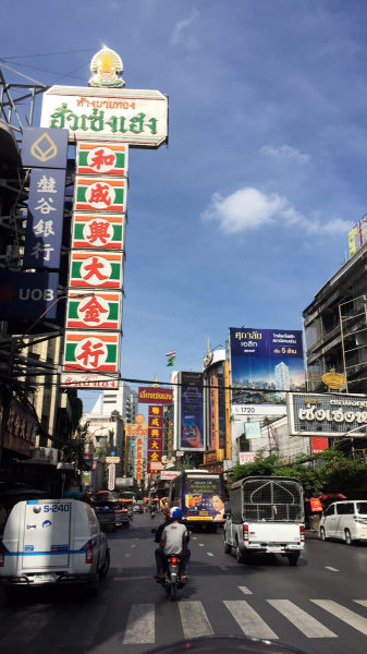 A typical old-meets-new street scene in Bangkok, filled with street signs.